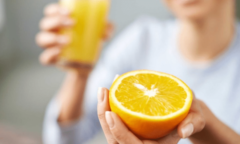 femme avec un verre et une orange