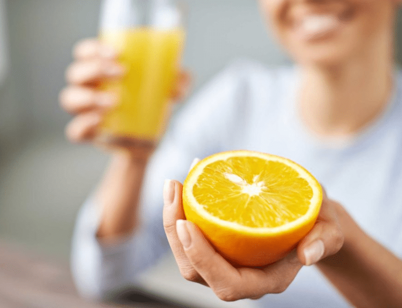 femme avec un verre et une orange