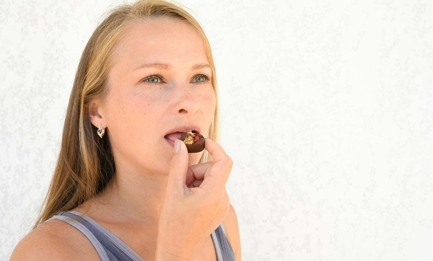 Femme Blonde qui mange un chocolat