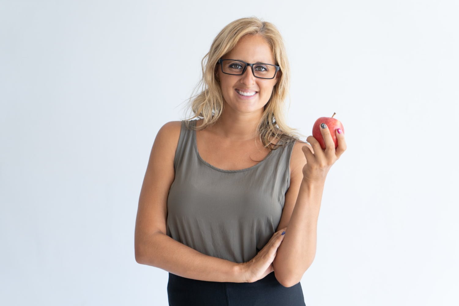 Femme avec des lunettes tenant une pomme dans la main